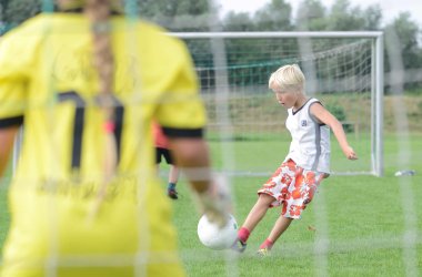 Symbolfoto - Junge schießt mit einem Fußball in Richtung Tor.